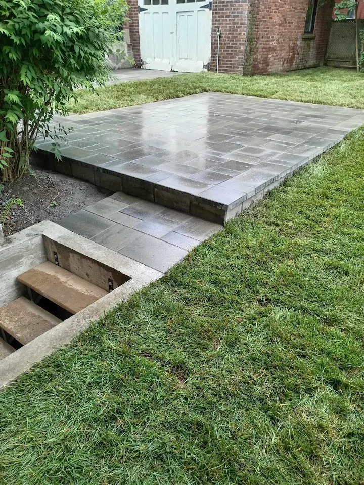 Raised stone patio built around a landscaped lawn