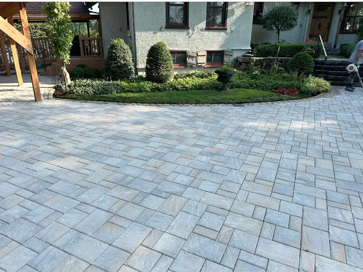 Stone-look paved driveway curving around a garden